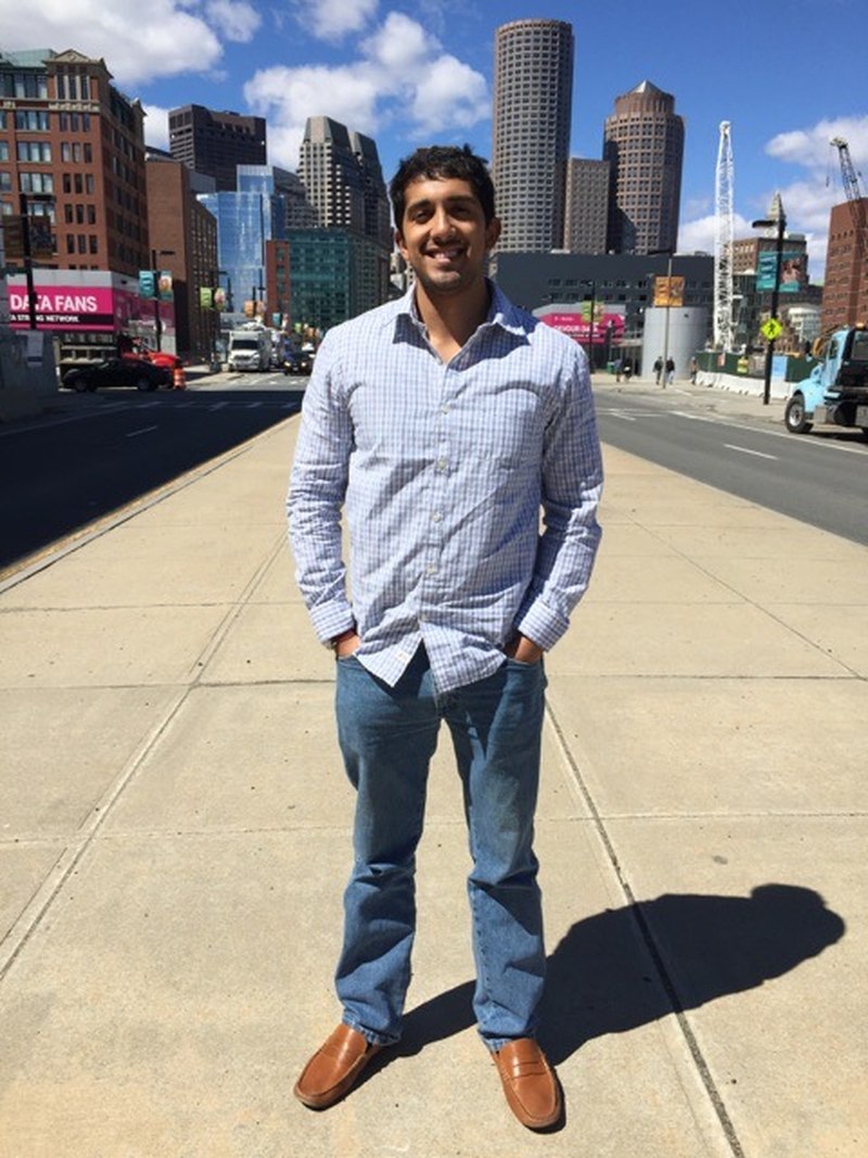 Raj as a young man standing on a Boston sidewalk